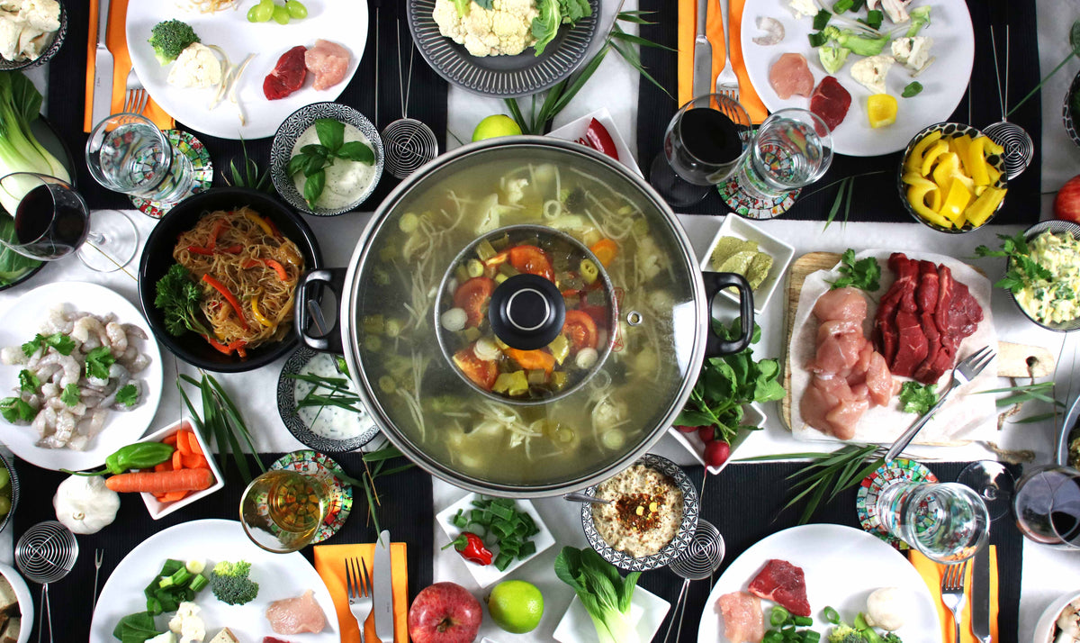 Table de fête vue du dessus autour d’un appareil à fondue chinoise Rotel